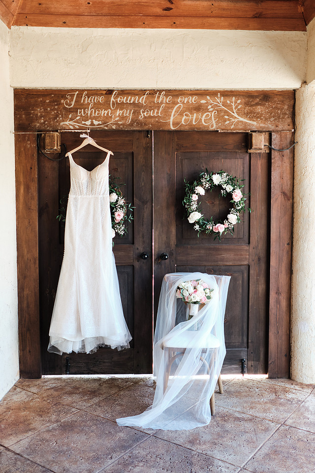 A wedding dress hanging on the carved wooden doors at Longan's Place